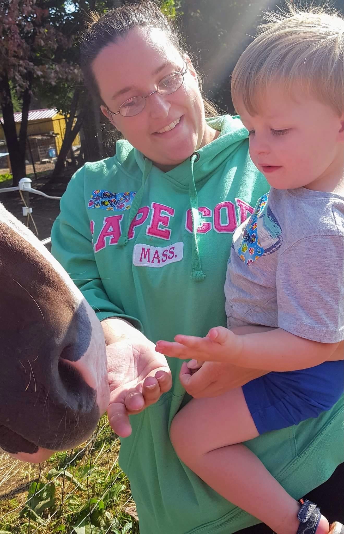 Sarah L. Proctor and child feeding a horse.