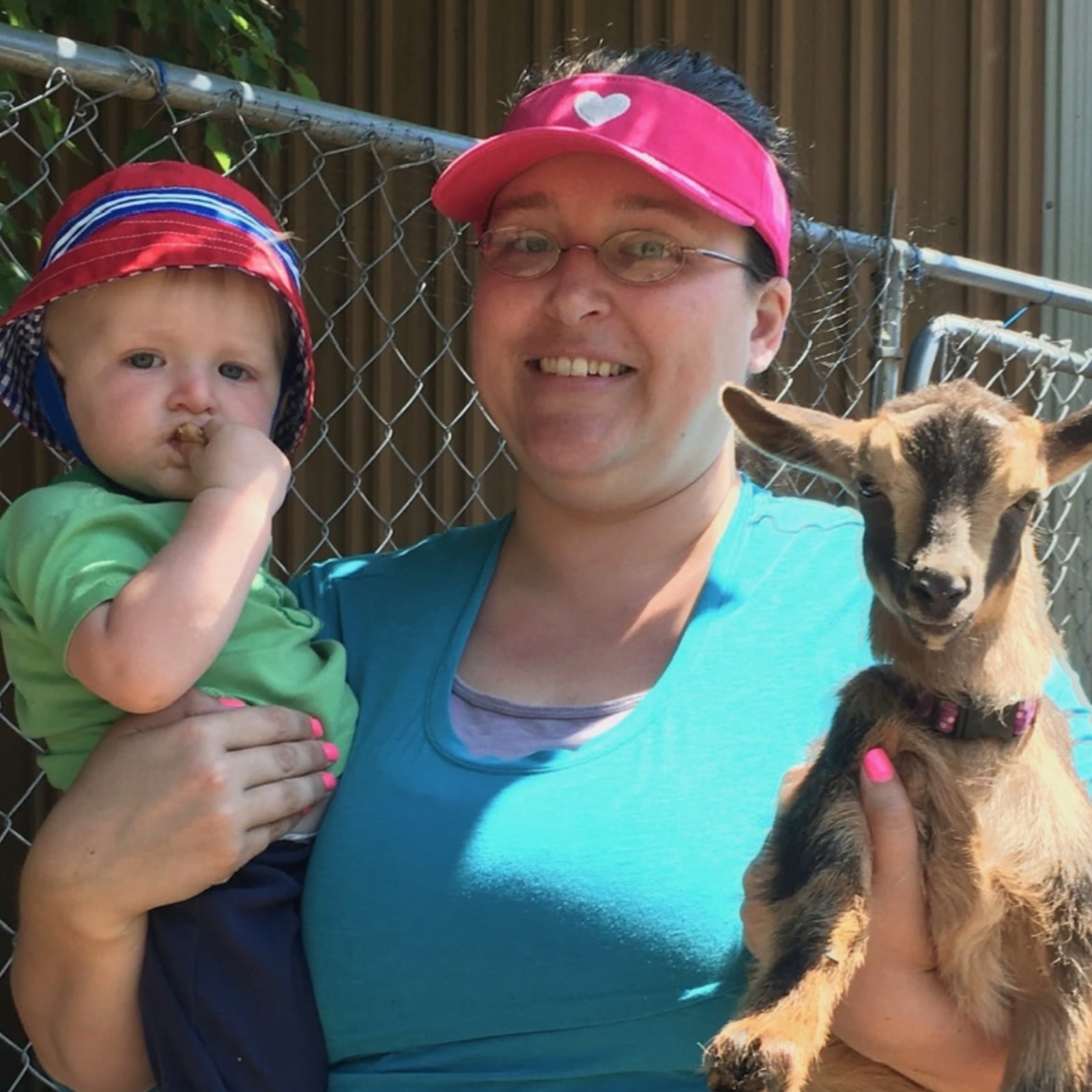 Sarah holding a baby and a goat.