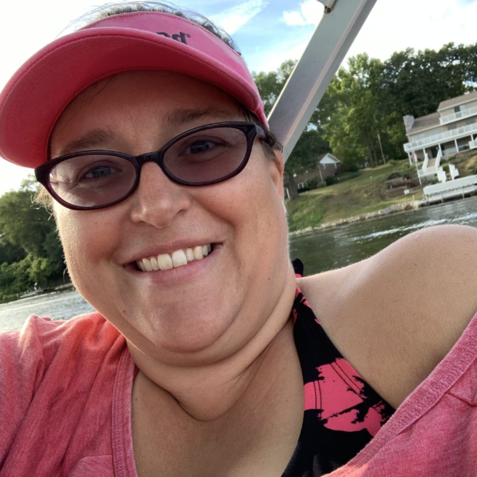 Sarah wearing glasses and a hat on a boat.